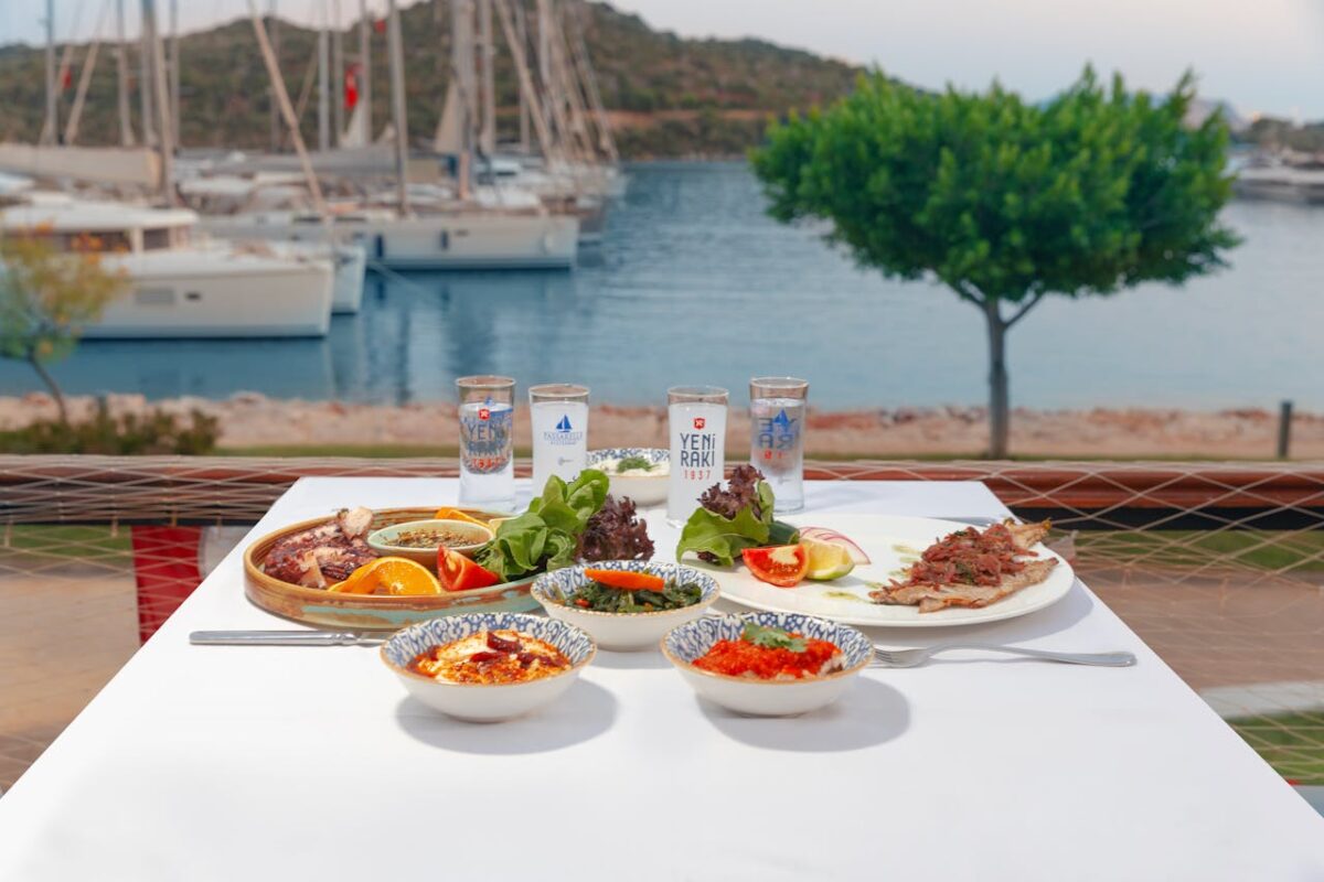 Enjoy a Mediterranean seafood meal by the sea with yachts in the background.